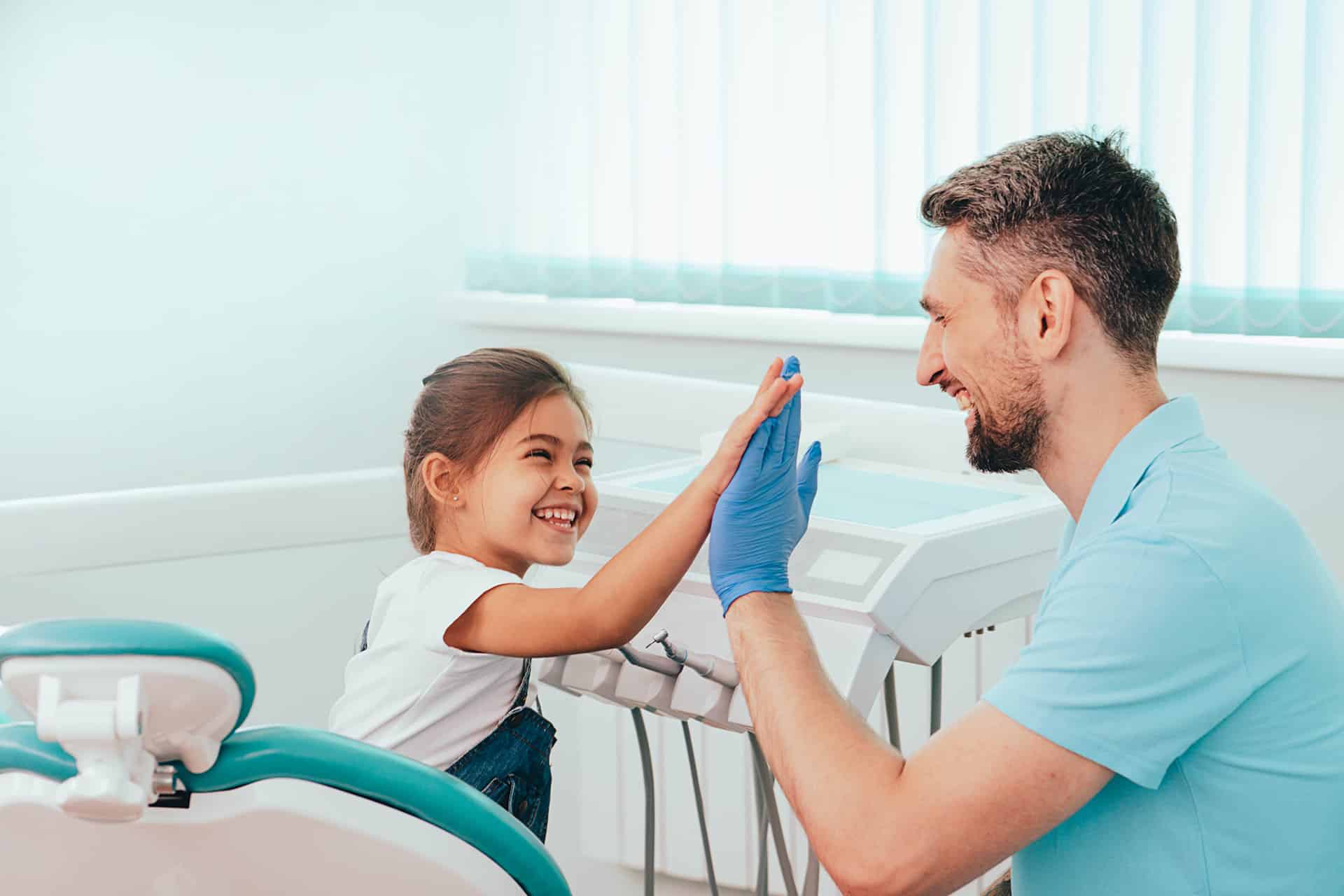 child high fiving dentist in Brooklyn, NY