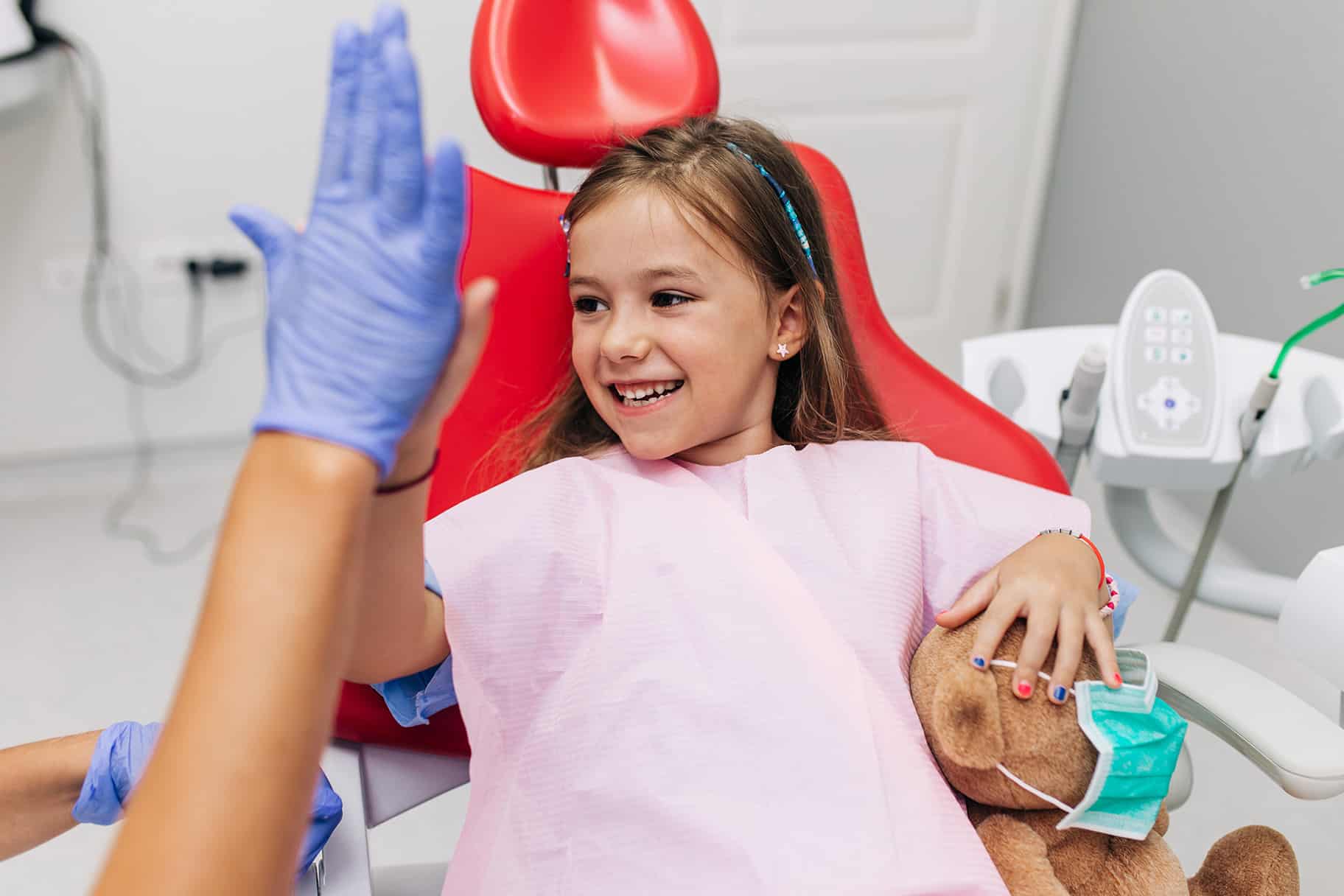 girl at dentist giving high five - Pediatric Dentistry on Kimball