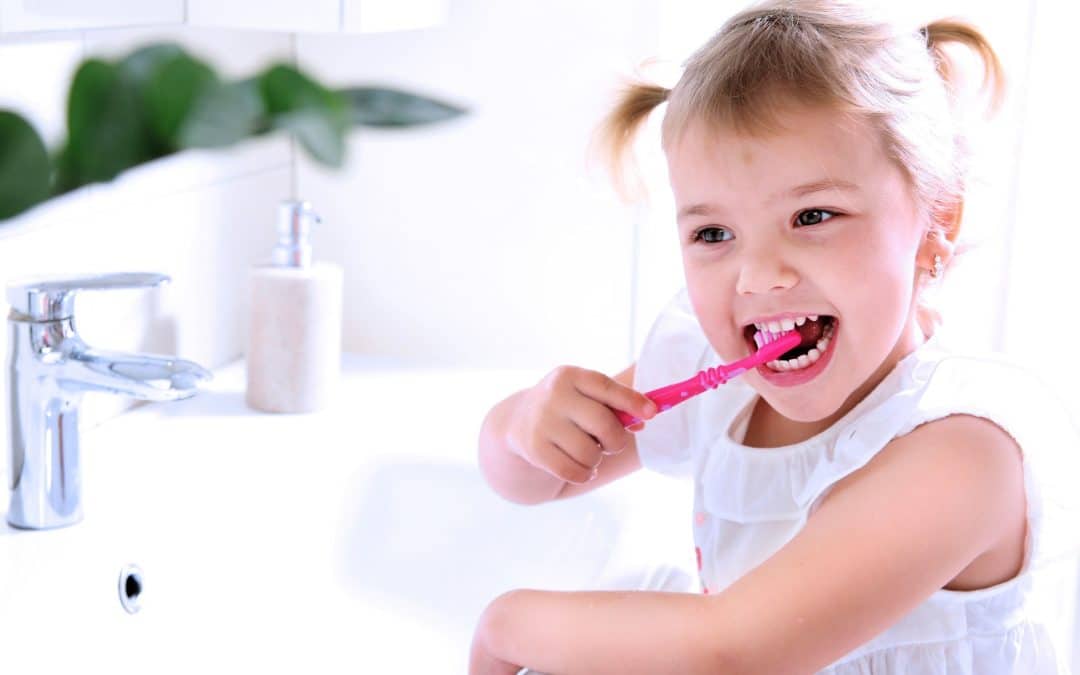 Girl brushing her teeth after getting a pediatric dental crown with Dr. Vera in NY